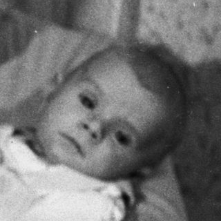 Woman holds baby, possibly during the holiday season.