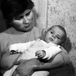 Woman holding baby in black and white photograph.