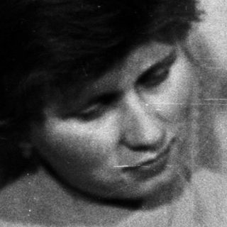 Woman holding baby in black and white photograph.
