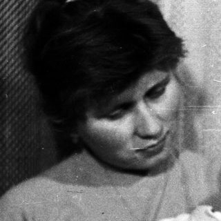 Woman holding baby in black and white photograph.