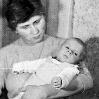 Woman holding a baby, possibly during the holiday season.