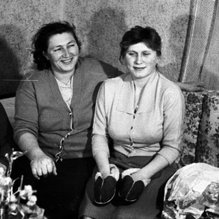 Black and white portrait of a family seated on a couch.