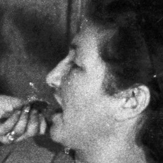 Two women appear to be smoking near a Christmas tree.