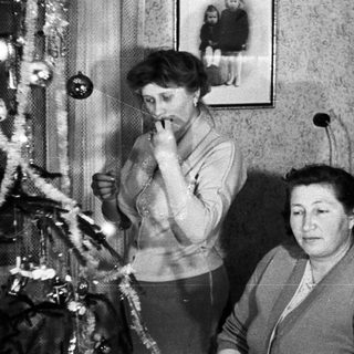 Two women near a decorated Christmas tree.