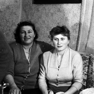 Two women and a child seated on a floral couch.