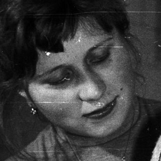 Woman holding a baby in a black and white photograph.