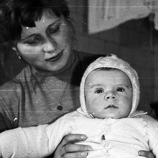 Woman holding a baby in a black and white photograph.