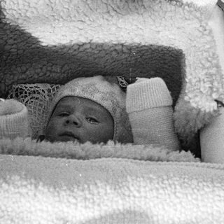 Black and white photo of a baby in a crib.