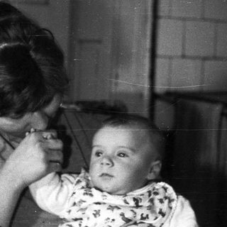 Woman appears to be administering medicine to a baby.