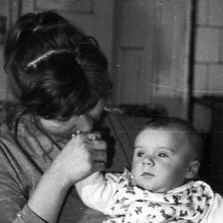 Woman appears to be administering medicine to a baby.