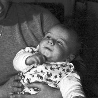 Woman holding baby, black and white portrait.