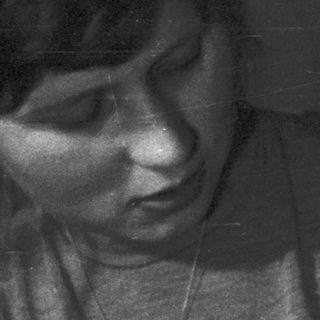 Woman holding baby, black and white portrait.
