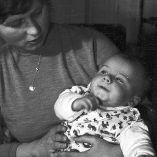 Woman holding baby, black and white portrait.