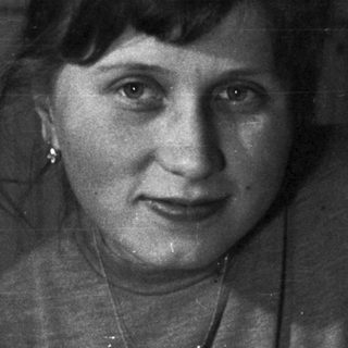 Woman holds baby, posing for a black and white portrait.