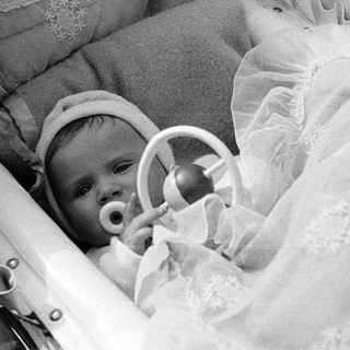 Black and white photo of a baby in a basket.