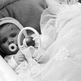 Black and white photo of a baby in a crib.
