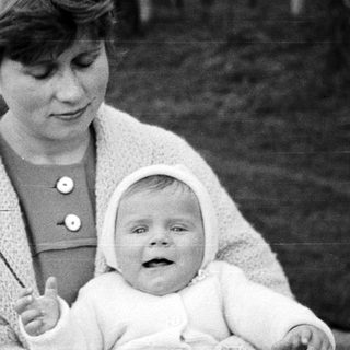 Woman holding a baby in a vintage black and white photo.