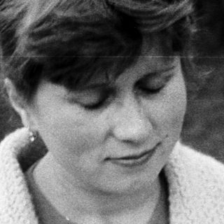 Woman holding a baby in a vintage black and white photo.
