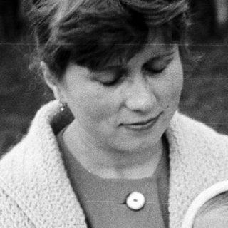 Woman holding a baby in a vintage black and white photo.