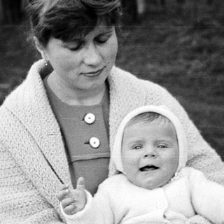 Woman holding a baby in a vintage black and white photo.