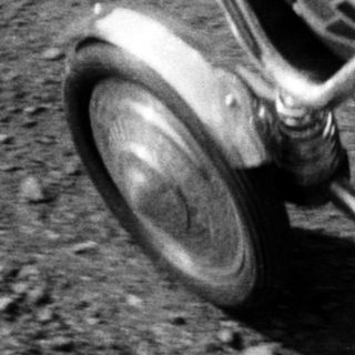 Baby in vintage stroller, captured in black and white.