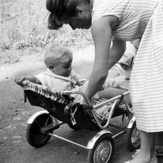Black and white photo of a woman and child with a stroller.