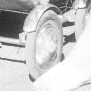 Baby in a stroller being pushed along a path.