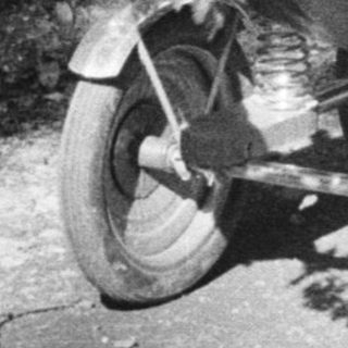 Baby in a stroller, being pushed along a path.