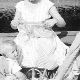 Black and white photo of a woman and child in a boat.