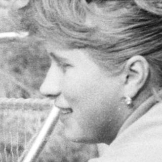 Woman with child in vintage stroller outdoors.