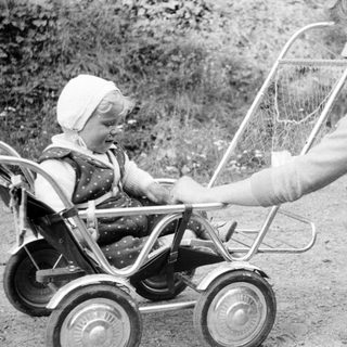 Woman with child in vintage stroller outdoors.