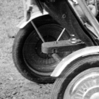 Woman with child in vintage stroller outdoors.