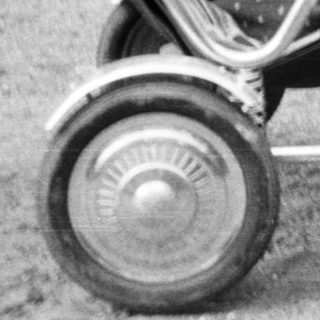 Baby in a pram with a woman nearby.