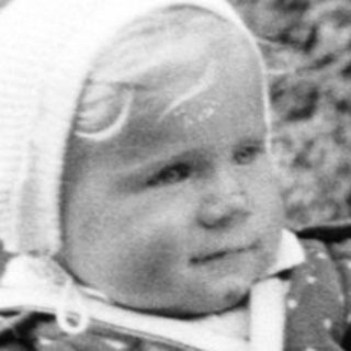 Baby in a stroller, being pushed by an adult.