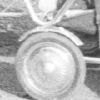 Man stands outdoors, pushing a baby carriage on a path.