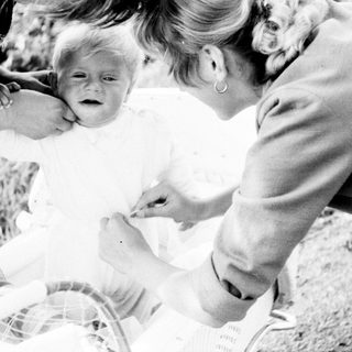 Woman tending to a crying baby in a stroller.