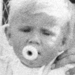Woman tending to a baby in a vintage stroller.