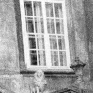 Two women stand on stone steps of an ornate building.