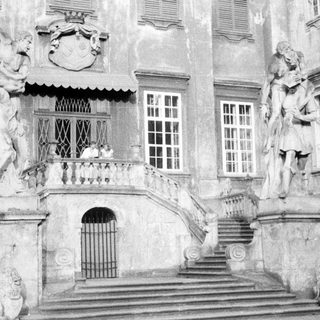Ornate entrance with statues and steps of a grand building.