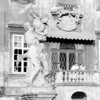Ornate entrance with statues and steps of a grand building.
