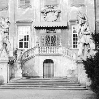 Monumental staircase with statues leading to a grand building.