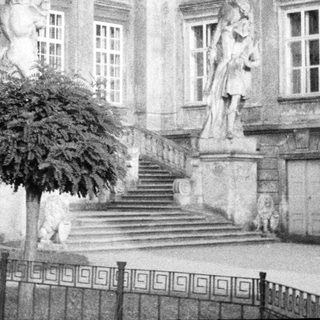 Black and white image of a stately building and statues.