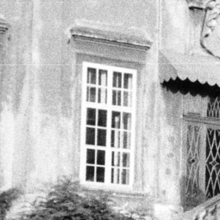 Black and white image of a stately building and statues.