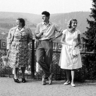 Three people pose outdoors, overlooking a landscape.