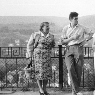 Three people standing outdoors, possibly overlooking a landscape.
