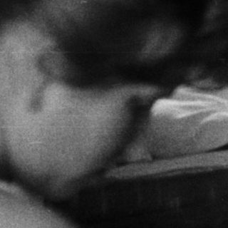 Woman and girl in a bedroom, reflected in a mirror.