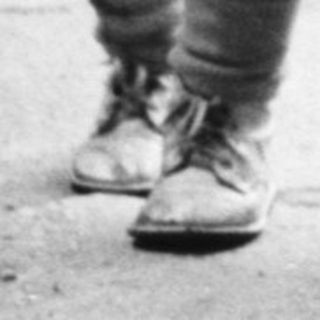 Child stands near a basket, woman sits nearby.