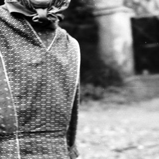 Black and white image of a person in patterned clothing.