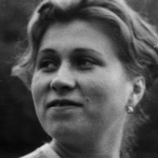 Black and white portrait of a woman outdoors.