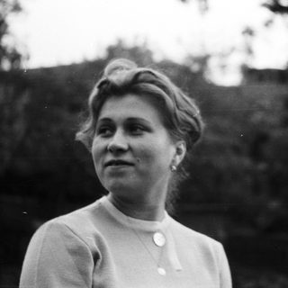 Black and white portrait of a woman outdoors.